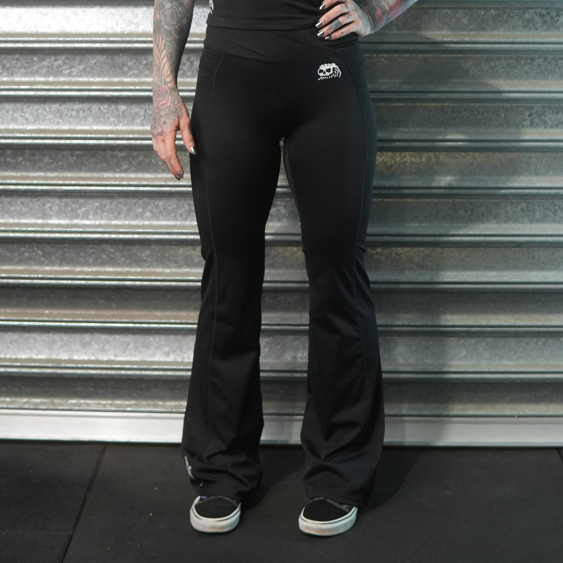Black flared athletic pants with Dead Tide skull logo and dagger print – alternative gymwear by Dead Tide